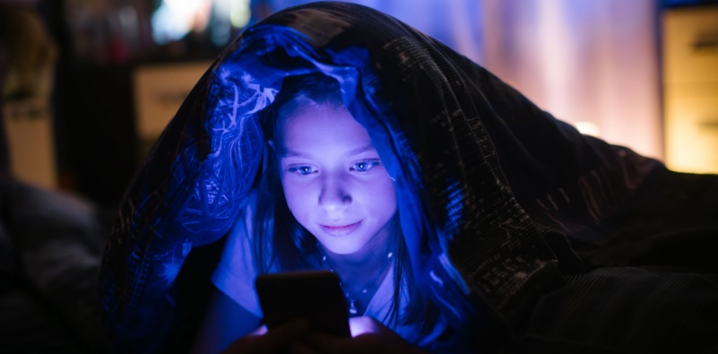 kid watching cell phone in dark leading to risk of Myopia