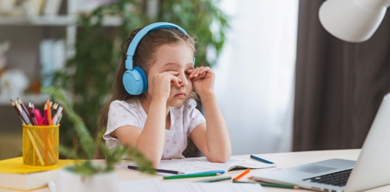 a kid rubbing her eyes due to short sightedness