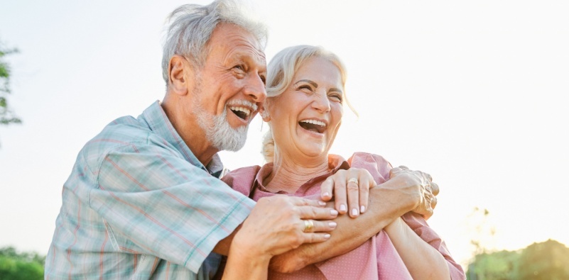 An older couple smiling outdoors